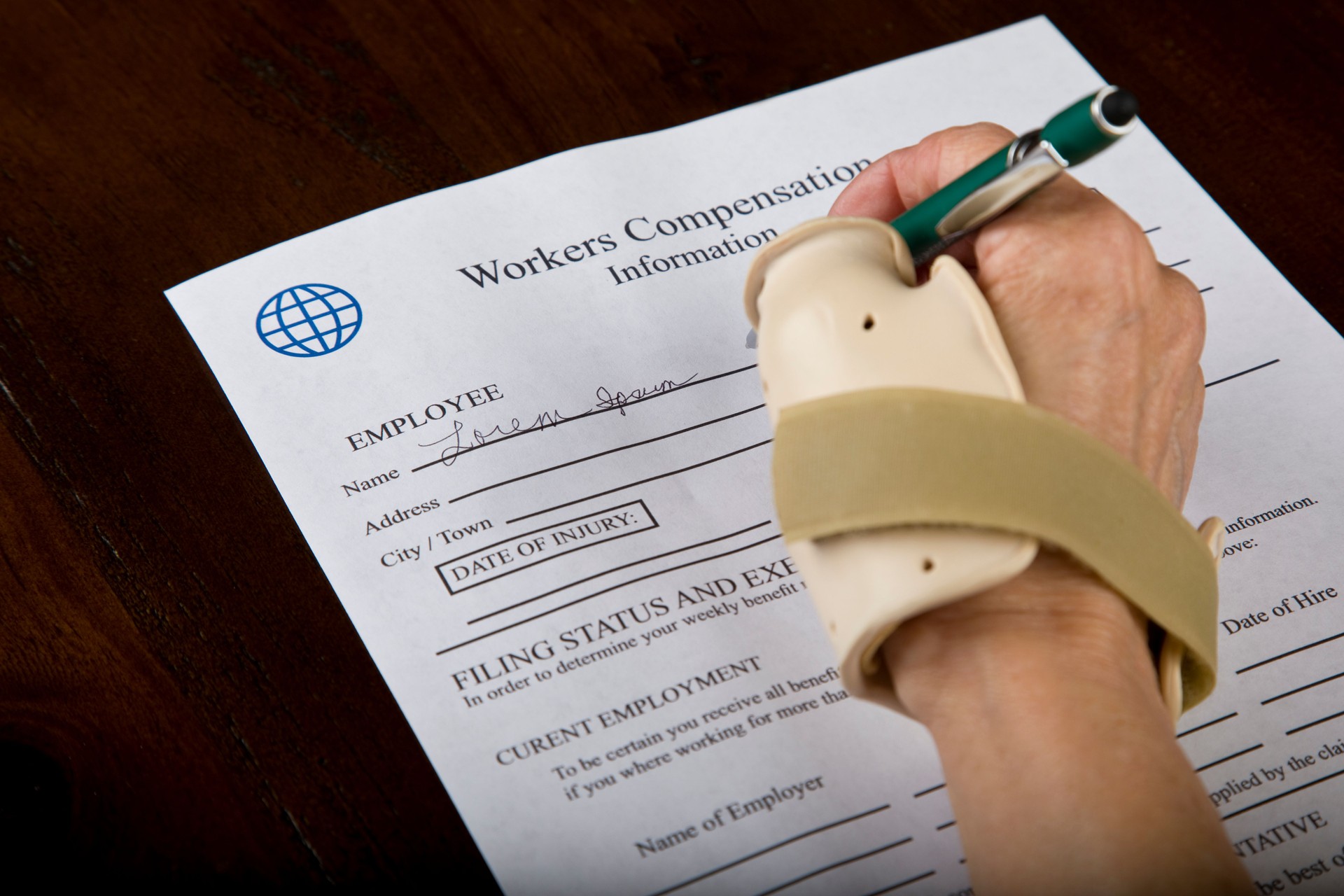 Woman in thumb brace signing name on Worker Compensation Form